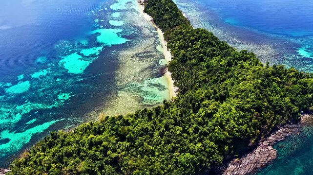 Aerial view of Port Barton Beach surrounded by lush tropical forest and vibrant coral reefs in the clear turquoise waters of Mimaropa, Philippines.