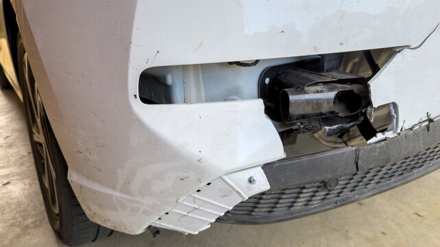 White car with rear end damage from a car accident showing damaged body, mising tail light and broken bumper