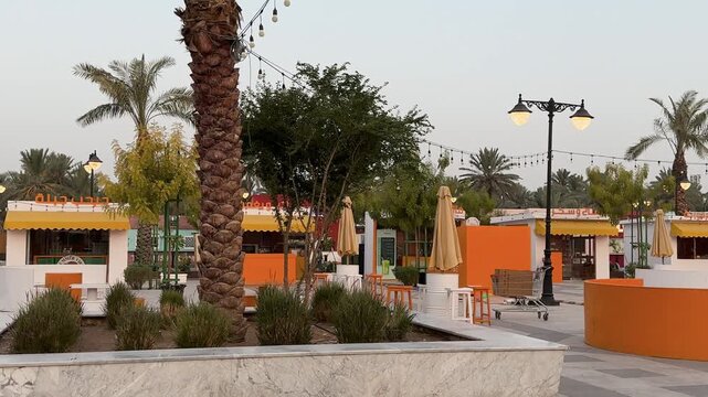 View of colorful outdoor food stalls and a seating plaza near Masjid Quba in Medina.