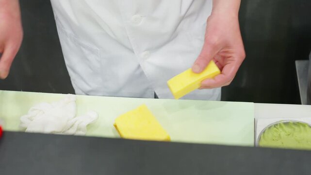 Japanese sushi chef slicing tamago egg omelet for sushi preparation in restaurant kitchen, traditional food cooking process with fresh ingredients for Japanese cuisine and professional culinary work.