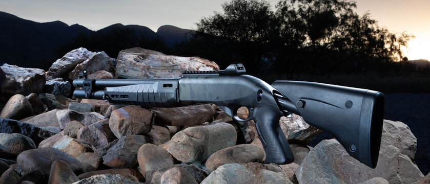 Tactical shotgun outoor on rocks with the setting sun behind