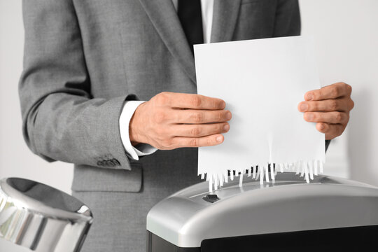 Data privacy and document security, businessman shredding confidential paper document to protect sensitive information and prevent identity theft