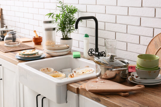 Household chores and domestic stress, pile of dirty dishes in kitchen sink with messy countertop and unwashed cookware after dinner party at home