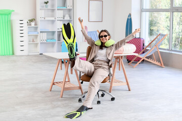 Vacation planning and work life balance, happy woman in office wearing travel gear and flippers dreaming of summer holiday and tropical beach getaway © Pixel-Shot