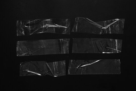 Adhesive tape strips, graphic design elements and collage textures with wrinkled plastic texture on a black background