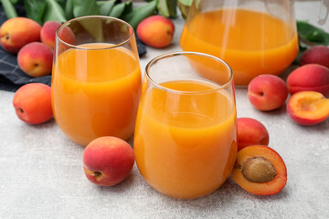 Apricot juice, fresh fruits and leaves on light table, closeup © New Africa