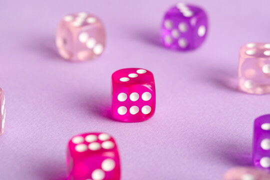 Different game dices on lilac background