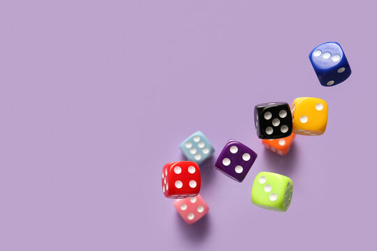 Flying colorful game dices on lilac background