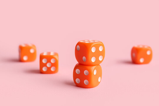 Orange game dices on pink background