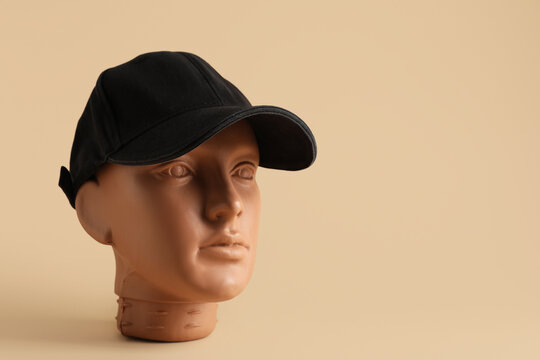 Plastic mannequin head with blank cap on color background