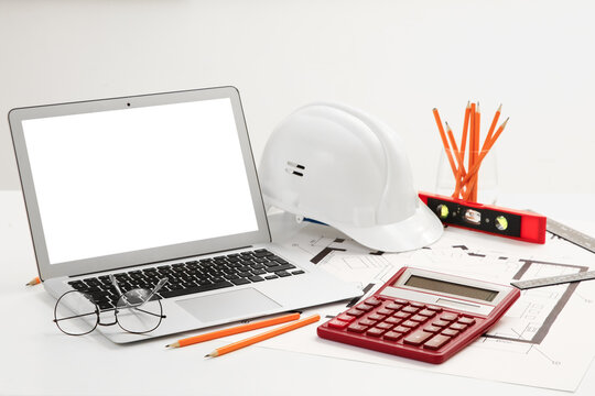 Blank laptop with constructors supplies on table in office