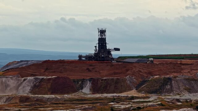 Aerial view of the massive bucket-wheel excavator at Tagebau Hambach open-pit mine, surrounded by vast layers of excavated earth in Elsdorf, Nordrhein-Westfalen, Germany.