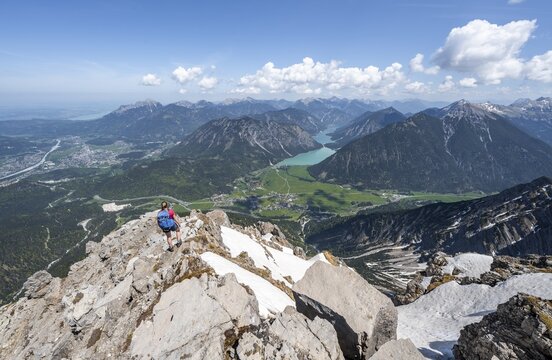 Hiker looking down from Thaneller to Plansee and eastern Lechtal Alps, Tyrol, Austria