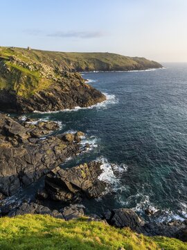 Coastal landscape at Botallack Mine, also known as Crown Mine. The ruins of Wheel Edward in the background. Sea and rocks. Evening, golden hour. Good weather, blue sky. Botallack, Penzance, Cornwall, England, Great Britain