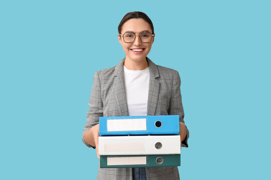 Young businesswoman in eyeglasses with document folders on blue background