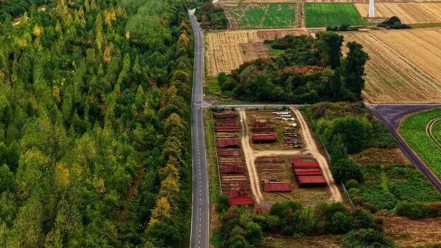 Aerial view of the landscape surrounding Tagebau Hambach with a road separating forest and agricultural fields in Elsdorf, Nordrhein-Westfalen, Germany.