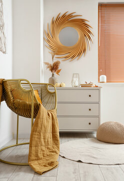 Interior of light living room with cozy armchair and commode