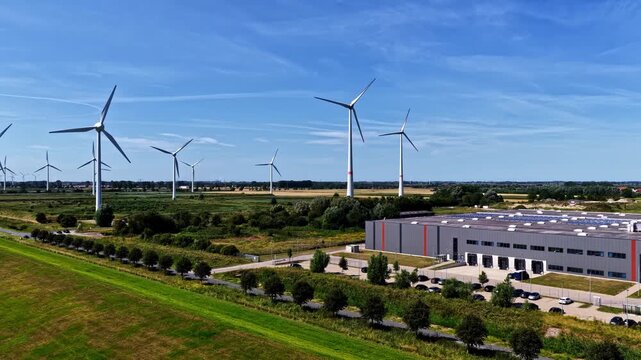 Aerial view of the Volkswagenwerk Emden factory surrounded by wind turbines and green fields in Emden, Niedersachsen, Germany.