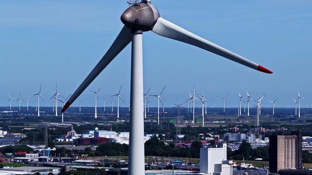 Aerial view of the wind turbine farm at the Volkswagenwerk Emden industrial facility under a clear blue sky in Emden, Niedersachsen, Germany.