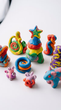 Colorful handmade playdough shapes and figures on a white background