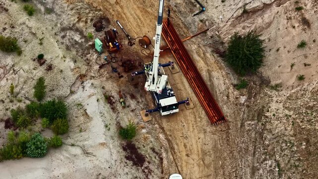 Aerial view of a mobile crane operating within the vast open-pit landscape of Tagebau Hambach in Elsdorf, Nordrhein-Westfalen, Germany.