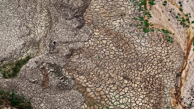 Aerial view of the cracked, dry earth at the Tagebau Hambach open-pit mine, showcasing the intricate patterns of parched soil and mineral deposits in Elsdorf, Nordrhein-Westfalen, Germany.