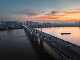 Obraz premium Aerial sunset view of Vinh Tuy Bridge over the Red River in Hanoi, Vietnam
