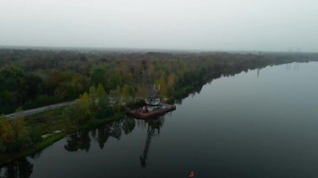 Drone footage of a Rusted Port crane in Prypiat river in Chernobyl Exclusion Zone of Ukraine.