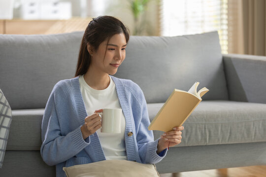 Relaxation concept, young woman drinking coffee while reading book on cozy sofa at home, enjoying peaceful leisure moment. relaxation, woman, coffee, reading, book.