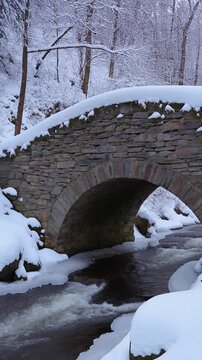 Stone Arch Bridge over a River in a Snowy Forest Generative AI