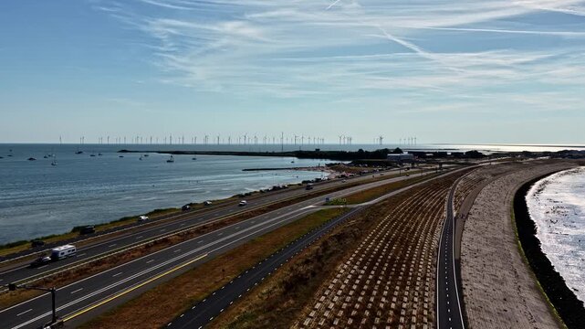 Aerial view of Windpark Fryslan offshore wind farm along the Afsluitdijk with highway and water in Breezanddijk, Friesland, Netherlands.