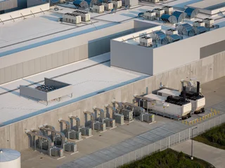 Aerial view of data center facility with cooling units and surrounding industrial infrastructure  © marchello74