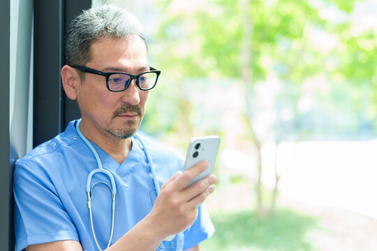 スマートフォンを使う中高年の医師