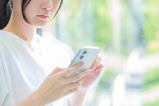 スマートフォンを使う看護師の女性の手元