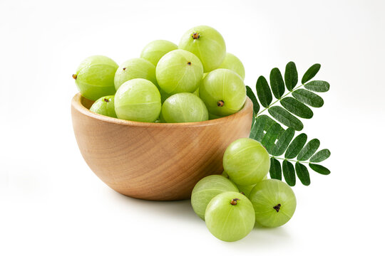 Fresh Indian Gooseberry (Amla) in Wooden Bowl with Green Leaves. Ideal for herbal medicine and organic health concepts.