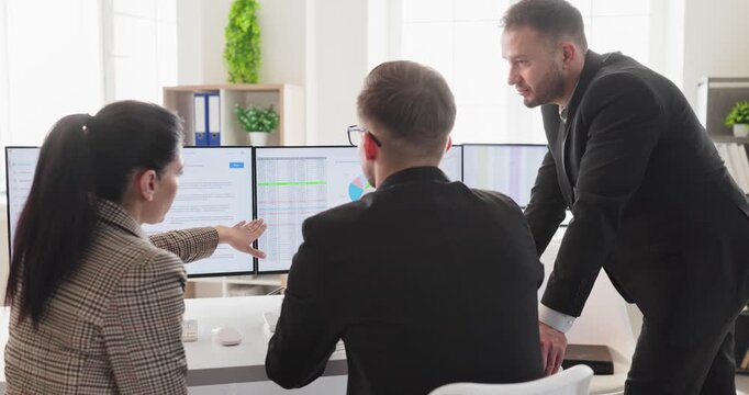 Business analysts team in office data analysis. Colleagues present charts on a computer during a meeting. They debate options and plan actions. Clear business team discussion concept image.