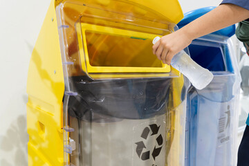 Plakat Hand Putting Plastic Bottle into Yellow Recycling Bin for Waste Management