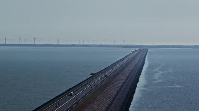 Aerial view of Windpark Fryslan and the Afsluitdijk causeway stretching across the water in Breezanddijk, Friesland, Netherlands.