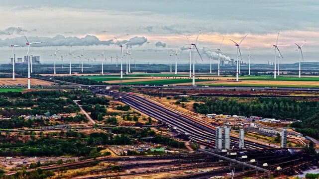 Aerial view of Garzweiler surface mine with numerous wind turbines, industrial infrastructure, and surrounding fields in Juchen, North Rhine-Westphalia, Germany.