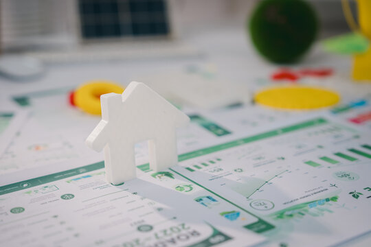 esg concept, White house model on financial document with calculator and coin symbolizing home purchase planning and mortgage budgeting