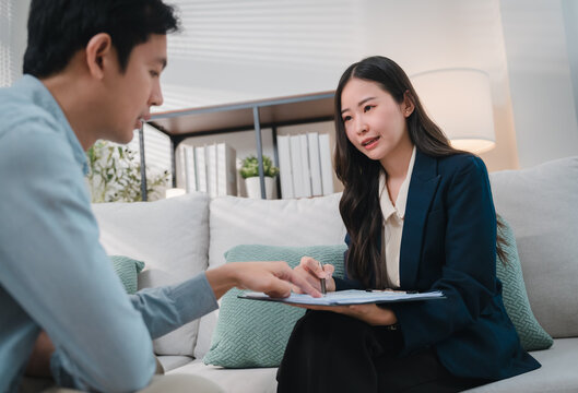 Financial advisor discussing wealth planning with client during professional consultation in modern office lounge, creating focused and supportive business meeting atmosphere
