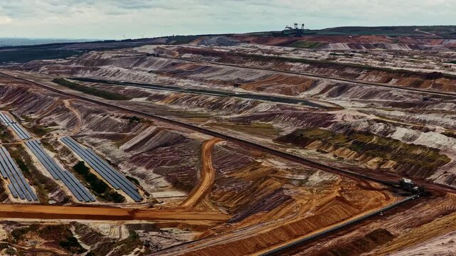 Aerial view of the vast Tagebau Hambach open-pit mine with deep excavation terraces, conveyor belts, and industrial infrastructure in Elsdorf, Nordrhein-Westfalen, Germany.
