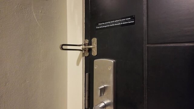 Closing Security Chain Latch on a Hotel Room Door
