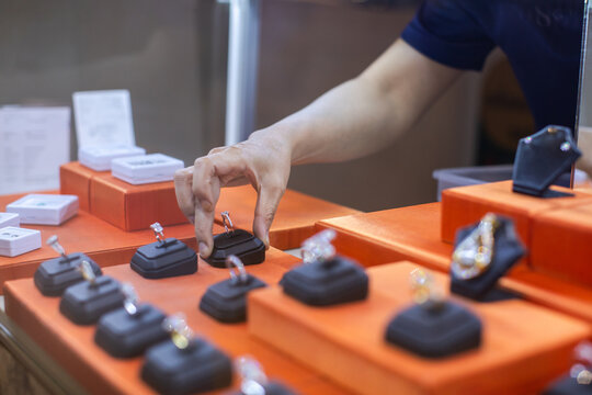 Customer Touching Diamond Ring Displayed on Showcase Counter in Jewelry Store