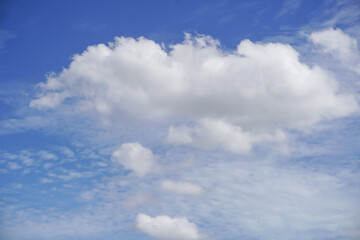 Fluffy white cumulus clouds drift across a vibrant blue sky © khomkrit