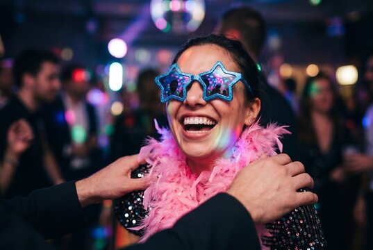 Young Woman Laughing in Nightclub with Star Glasses and Pink Feather Boa at Party Event