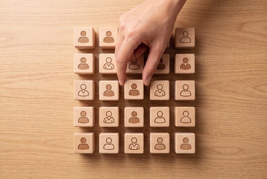 Hand Choosing Human Resource Selection Concept with Wooden Blocks and Person Icons