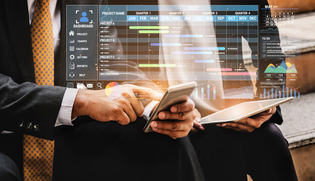 Business Professionals Analyzing Data on Mobile and Tablet Devices with Digital Dashboard in Modern Office Environment During Meeting Fluxor.
