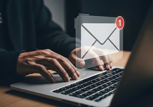 Person typing on a laptop with an email notification icon appearing, representing digital communication