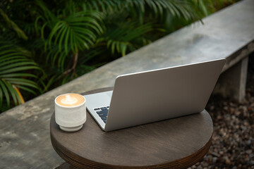 Obraz premium A freelancer enjoys coffee while working on a laptop outdoors